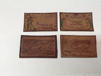 Front of four embossed leather postcards showing soldier motif, floral border sentiment, harbor scene and bright-day sentiment