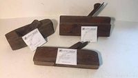 Set of three antique wood block planes laid out showing scale and labels.