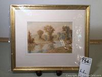 Front view of the framed watercolor landscape painting showing the gold frame and white matting.