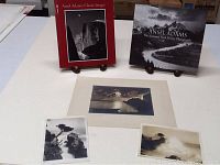 Five items including two Ansel Adams books at rear, two photos (black and white) on left and right front, and a matted photograph in center.