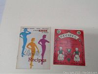 Two cookbooks shown: 'Silhouette Recipes' with illustrated silhouettes on white cover, 'Recipes Made Famous by the Pennsylvania Dutch' with folk art style floral and figures on red cover.