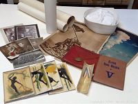 Photo showing entire assortment including maps, military photos, sailor hat, ration book holder, art pieces, and certificates.