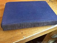 Top view of the closed book showing blue cloth cover in good shape with minor wear.