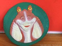 Front view of the green frisbee showing the 3D raised image of Jar Jar Binks' face with yellow eyes and detailed smile.