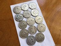 Front side view of seventeen Canadian 5 cent coins laid out in rows, showing the beaver design and dates from 1951 to 1957.