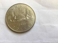 Reverse side of 1980 Canadian silver dollar showing Voyageur canoe design with year 1980 and inscriptions.