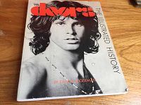 Close-up of the book cover showing Jim Morrison and the title 'The Doors The Illustrated History' with author's name Danny Sugerman.