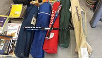 Four camping chairs packed in various colored carrying bags along with Easton youth baseball bat and Wilson DeMartini Patriot bat.