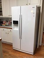 Full front view of white Samsung side-by-side refrigerator in kitchen setting