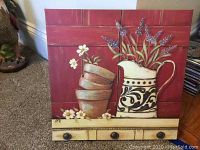 Wall art painting showing potted plants and decorative pitcher against reddish background with drawer front detail at bottom