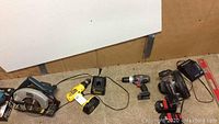 Photo of three power tools: Porter Cable circular saw, two cordless drills (Porter Cable and another yellow drill), battery charger, and Mikita jig saw.