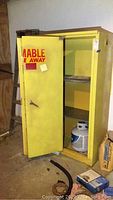 Yellow fire proof metal cabinet with open door showing interior and exterior wear.