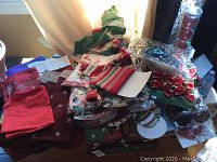 Table loaded with Christmas stockings, ribbons, decorations, bows and balls packed and ready for sale.