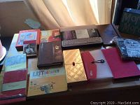 Photo showing arranged journals, notebooks, and paper goods on a wooden table with natural light.