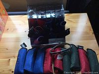 Multiple pairs of magnifying sunglasses in various colored cases displayed in a box and bag, showing overall quantity and packaging.