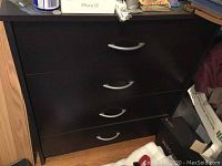 Photo of the black dresser showing the four drawers with curved silver handles.
