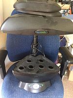 Full view of AeroGarden system with light, pod basins, and base control panel featuring AeroGarden logo.