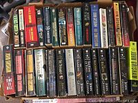 Photo showing two large boxes filled with books mainly by John Grisham along with other authors