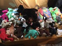 Photo showing a wide assortment of Ty Beanie Babies including bears, dogs, penguin, frog, and other animals in various colors with most tagged