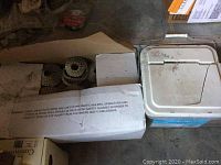 Photo of box and bucket containing roofing nails and coil nail gun nails.