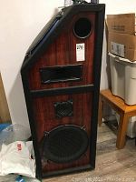 Front view of a large speaker showing its multiple drivers and wood finish