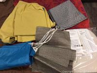 Kora chair covers yellow fabric, blue laundry bag, black and white recycled placemats, IKEA instructions visible