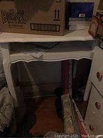 Vintage telephone table painted white with gold accents on legs, showing front and side views.