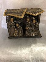 Front view of the heavy, glossy glazed nativity set including Mary, Joseph, baby Jesus and the wise men arranged inside a stable with detailed roof.