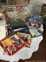 Photo showing entire lot: board game, DVDs, calendars, scarf with tags