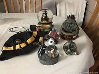 Photo of Harry Potter collectibles on table including water globes, music box, pewter Hagrid figurine, night light, and hat