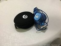 Blue Beats wired over-ear headphones with 3.5mm wired plug and black soft zippered carrying case with white Beats logo