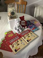 Full display of lot on table showing puzzles, books, bears, gift bags