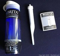 Blue Brita water bottle with white cap, showing front label indicating it is a hard sided bottle with an internal filter, new and unused.