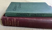Side view of two vintage books stacked, titles visible on spine: Correct Conduct and What a Young Boy Ought to Know.