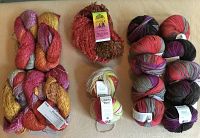 Overall lot arranged on surface showing all yarn hanks and skeins