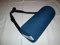 Full side view of lumbar support roll on white surface showing blue textured fabric and black adjustable strap