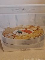 Box image showing the platter with chips, bread, and dips with Bella Cucina logo and 'Heated Party Platter' label.