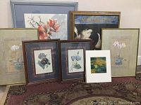 Group shot of 7 framed flower-themed artworks and a landscape print