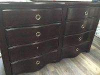 Front view of solid wood dresser showing eight drawers and metal ring handles