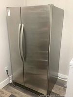 Exterior view of stainless steel side-by-side refrigerator-freezer showing doors and integrated handles.