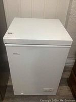 Front view of white Danby Diplomat chest freezer with closed lid and front control panel