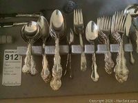 Mixed spoons and forks including serving and dinner pieces in foam tray