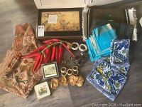 Pimpernel embroidered placemats, napkins, napkin rings, decorative coasters, chili pepper ornament laid out on floor