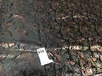 Silk fabric spread out showing dark background with colorful pagoda and floral pattern, fabric label visible with lot number.