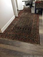 Full view of the carpet laid on a hardwood floor showing pattern and size.
