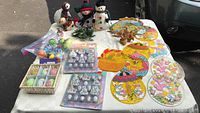 Overview of various Christmas and Easter decorations arranged on a table, including snowmen, Easter plates, ceramic ornaments, and plastic eggs.