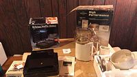 Table showing Salton Belgian Waffle Maker and Cuisinart Food Processor with their original boxes and accessories.
