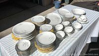 Complete display of dinnerware set arranged on table showing all plate types, bowls, cups, platters, and serving pieces.