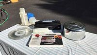 Photo of Rival Seal-A-Meal Plus Vacuum Sealer, storage containers, cake plate, cake cover, and boxed KüchenStolz knife set on a table outdoors.