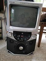 Front view of the Craig 13-inch color CRT TV with integrated CDG karaoke system including screen, control panel, and speakers.